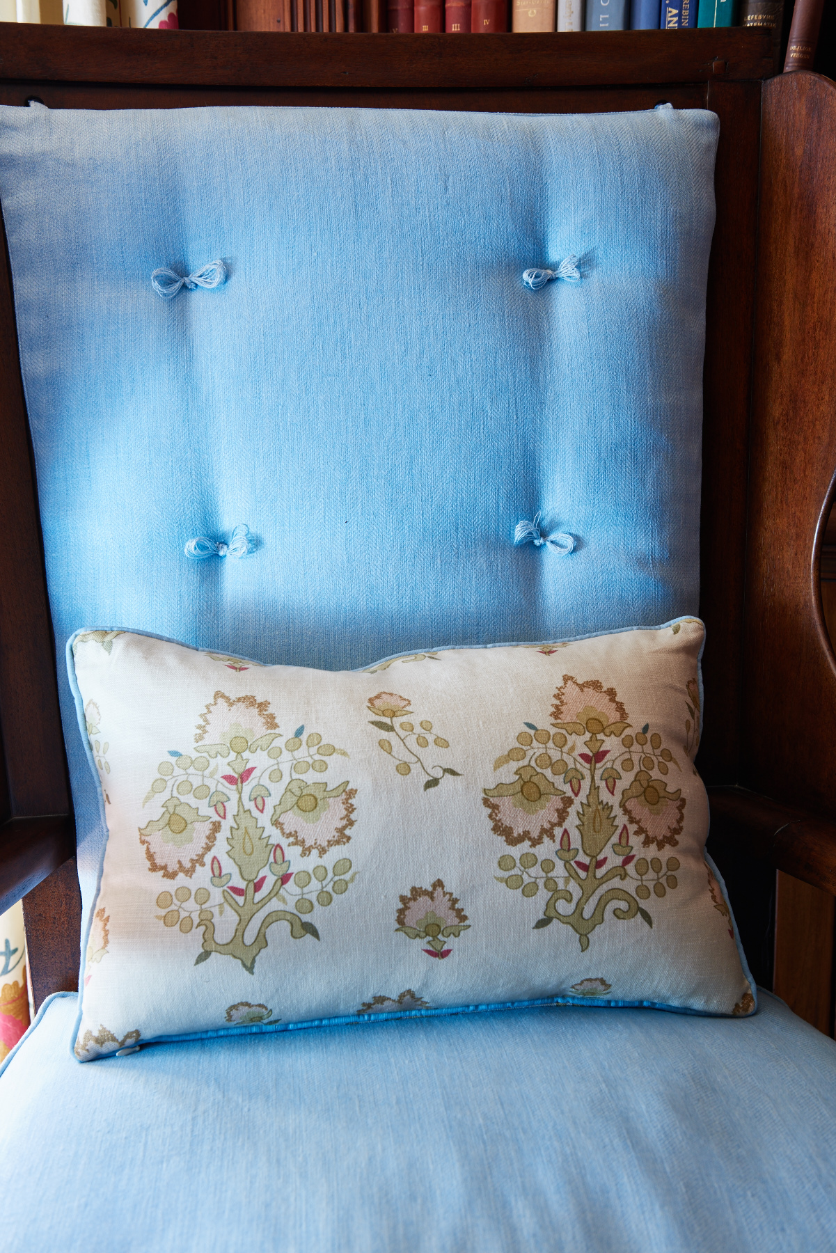 Blue upholstered chair with bow tie button accent
