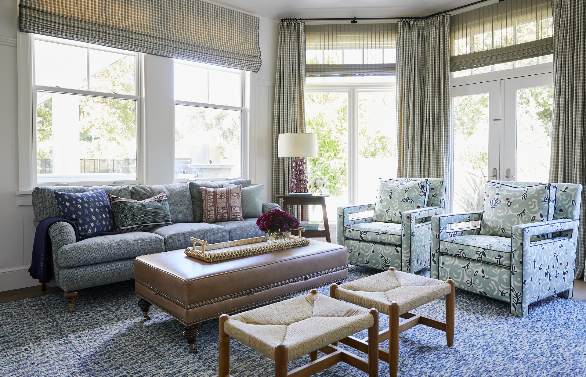 Checkered roman shades and pleated drapes with woven shades and upholstered seating