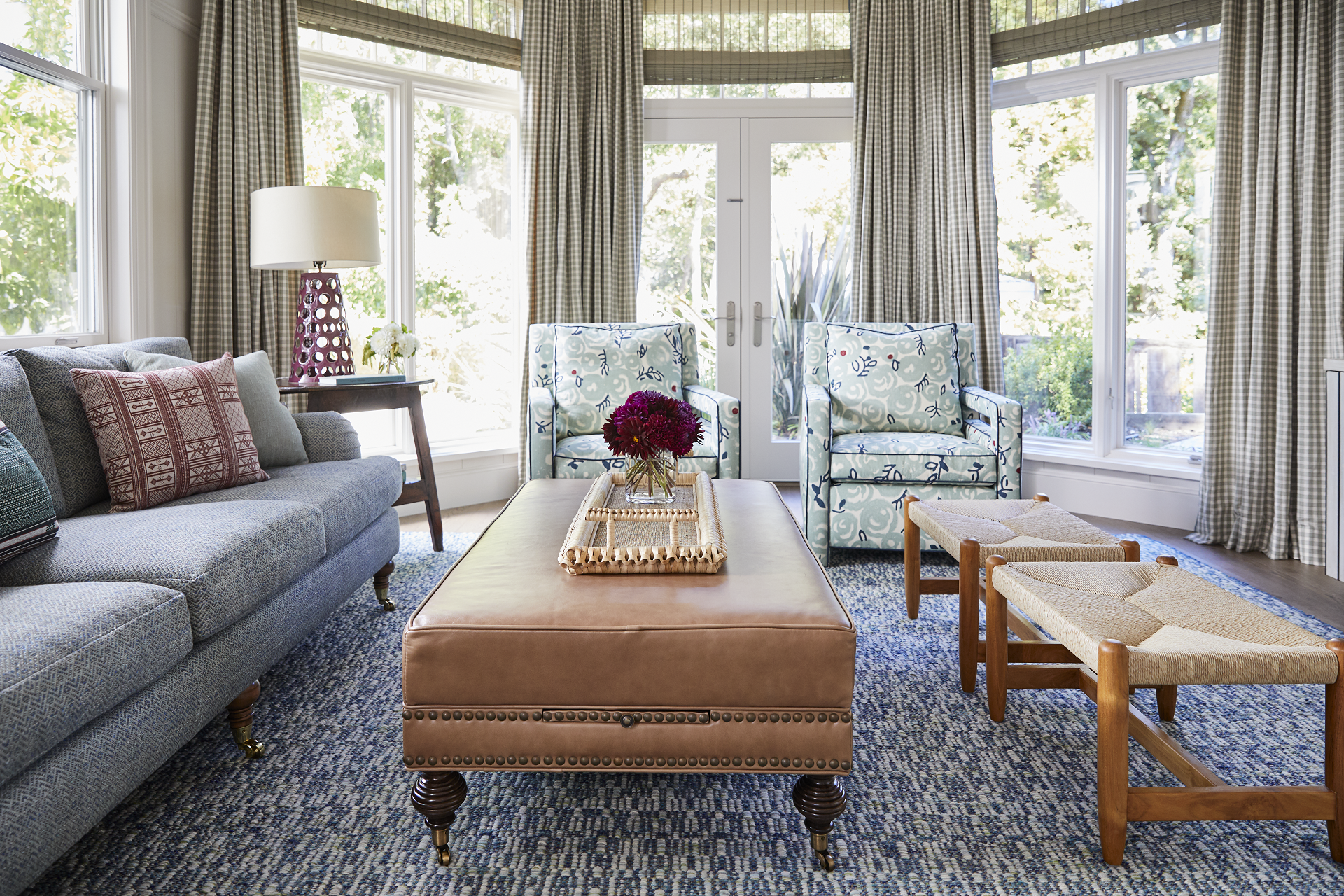 Checkered roman shades and pleated drapes with woven shades and upholstered seating different angle