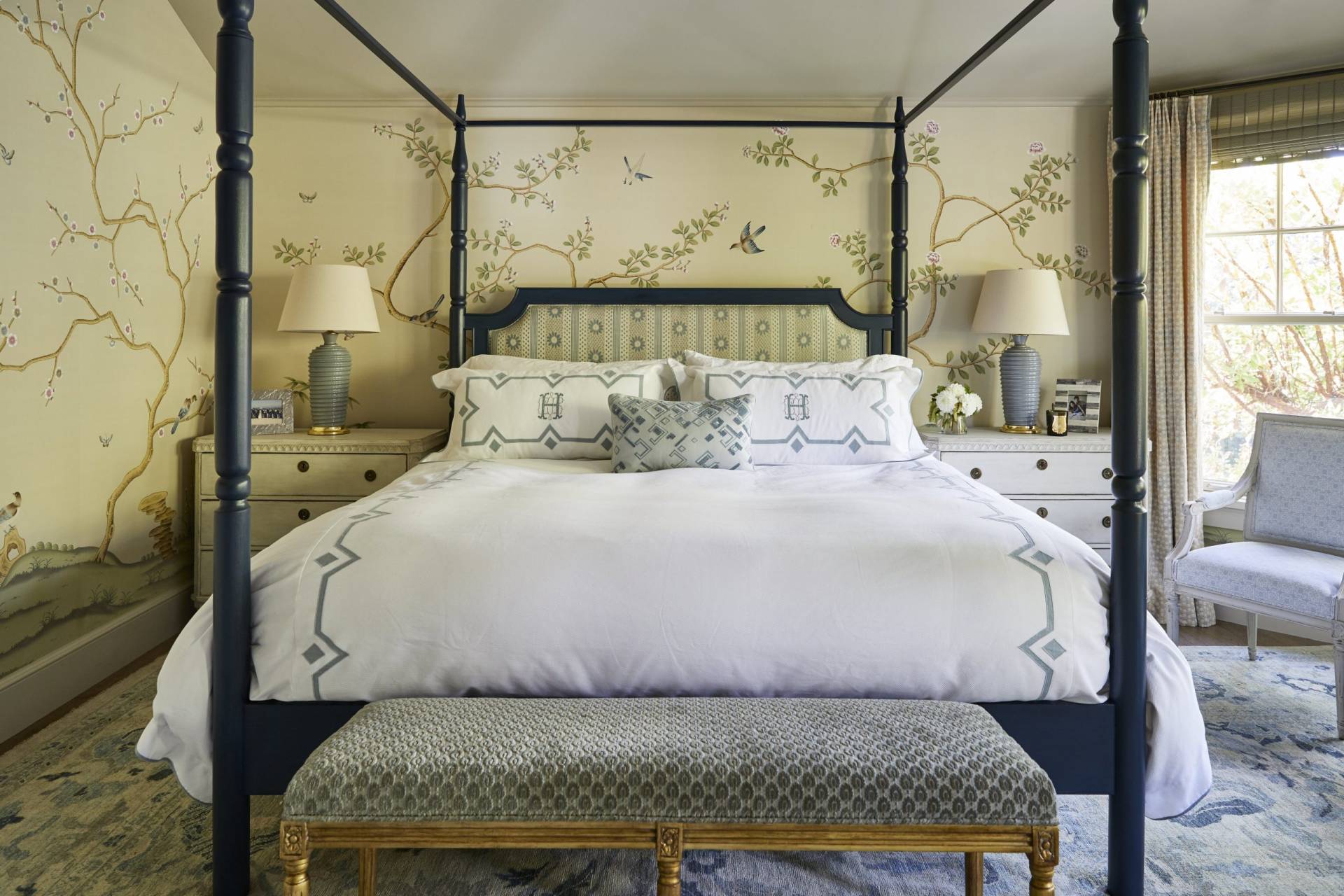 Wider view of upholstered headboard, custom bedding, and shams monographed