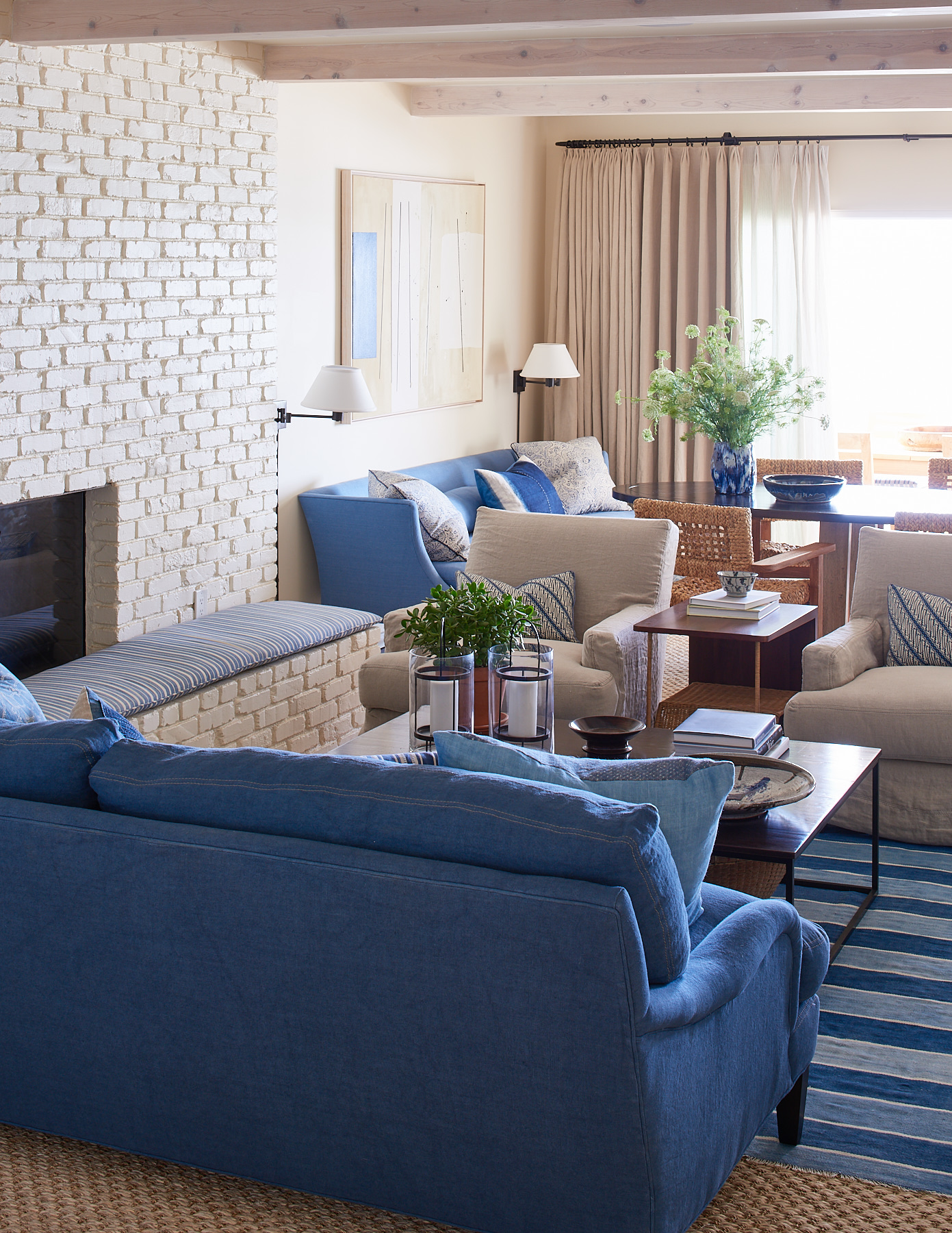 Beige linen club chairs, denim-style sofa, and horizontal-tufted settee.