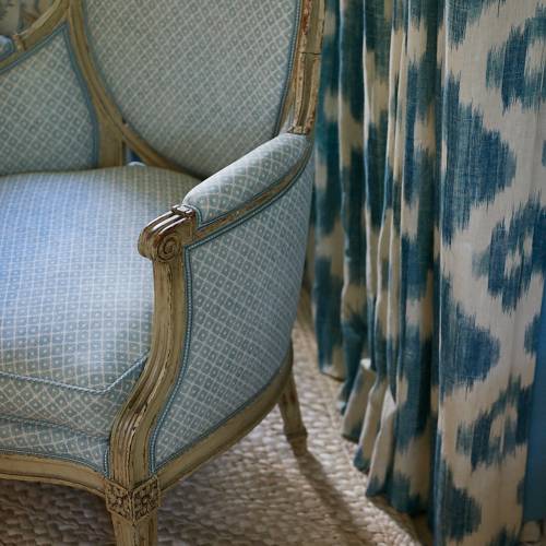 Detail of upholstered chairs and pleated blackout drapes